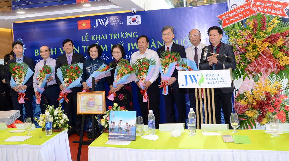 TS. BS. Nguyễn Phan Tú Dung tặng hoa cám ơn sự giúp đỡ của cơ quan, ban ngành và lãnh đạo đã tạo điều kiện giúp đỡ thành lập BV thẩm mỹ JW Hàn Quốc trong thời gian qua. Từ trái qua: Ngài Kim Soo Hoo (Tham tán Lãnh sự quán Hàn Quốc tại TPHCM); TS. Nguyễn Huy Quang (Vụ trưởng vụ pháp chế BYT); PGS. TS. Lương Ngọc Khuê (Cục trưởng Cục khám chữa bệnh BYT); PGS. TS. Trần Thị Trung Chiến (Nguyên bộ trưởng BYT); Bà Trương Mỹ Hoa (Nguyên Phó Chủ Tịch nước CHXHCN Việt Nam); Ông Huỳnh Văn Biết (PGĐ. Sở Y Tế TPHCM); TS. BS. Man Koon Suh (TGĐ Bệnh viện Thẩm mỹ JW toàn cầu); PGS. TS. Đỗ Quang Hùng (Trưởng khoa phẫu thuật tạo hình bệnh viện Chợ Rẫy kiêm tổng thư ký Hội thẩm mỹ TPHCM). Bệnh viện thẩm mỹ Hàn Quốc đường 50 Tôn Thất Tùng, Phường Bến Thành, TP.HCM
